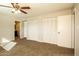 Inviting main bedroom with neutral carpet, large closets, a ceiling fan, and an ensuite bathroom at 4062 W Eva St, Phoenix, AZ 85051