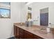 Bathroom with dual sinks, dark wood cabinet, and natural light at 4221 S Fireside Ct, Gilbert, AZ 85297