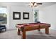 Bright game room features a wooden pool table, neutral carpet, and large windows at 4221 S Fireside Ct, Gilbert, AZ 85297