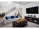 Open-concept living room with a staircase, plush seating, a large TV, and stylish accents at 4221 S Fireside Ct, Gilbert, AZ 85297