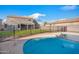 Backyard with a refreshing blue pool, black fencing, and lush green lawn at 4221 S Fireside Ct, Gilbert, AZ 85297