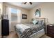Well-lit bedroom features a plush bed, window and ample space at 42519 W Centennial Ct, Maricopa, AZ 85138