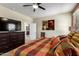 Well lit bedroom with walk-in closet entry, closet, dresser and ceiling fan at 42519 W Centennial Ct, Maricopa, AZ 85138