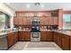 Well-equipped kitchen with stainless steel appliances and wooden cabinetry at 42519 W Centennial Ct, Maricopa, AZ 85138