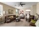 Cozy living room features neutral color, ceiling fan and opens to the kitchen at 42519 W Centennial Ct, Maricopa, AZ 85138