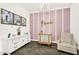 Charming Bedroom featuring a white dresser, crystal chandelier, striped accent wall and artwork to create a whimsical space at 4360 S Atom --, Mesa, AZ 85212