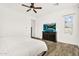 Bedroom with a ceiling fan, wood-look tile floor, dresser with TV and window with blinds at 4360 S Atom --, Mesa, AZ 85212