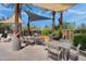 Inviting outdoor dining area featuring shaded seating, palm trees, and well-equipped barbecue grills at 4360 S Atom --, Mesa, AZ 85212