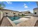 Inviting backyard pool with stone waterfall feature and desert landscaping under blue skies at 4360 S Atom --, Mesa, AZ 85212