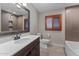 Bathroom with a wood framed mirror, tiled walk-in shower and wood cabinets at 4602 W Monte Cristo Ave, Glendale, AZ 85306