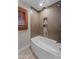 Bathroom with a soaking tub, and tiled walls with custom shelving niche at 4602 W Monte Cristo Ave, Glendale, AZ 85306