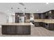 Well-lit kitchen featuring a large island, stainless steel appliances, dark wood cabinets, and tile backsplash at 4602 W Monte Cristo Ave, Glendale, AZ 85306