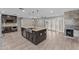 Open-concept kitchen featuring a large island, dark wood cabinets, stainless steel appliances, and tile flooring at 4602 W Monte Cristo Ave, Glendale, AZ 85306