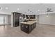 Open kitchen with an island, stainless steel appliances, dark cabinets, and ample counter space at 4602 W Monte Cristo Ave, Glendale, AZ 85306