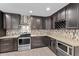 Modern kitchen with dark cabinets, stainless steel appliances, tile backsplash, and a built-in wine rack at 4602 W Monte Cristo Ave, Glendale, AZ 85306