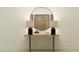 Elegant console table with lamps and decor, featuring a round mirror at 4808 S 232Nd Ln, Buckeye, AZ 85326