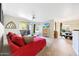 Bright living room with a red sofa, ceiling fan, sliding doors to a patio, and an entertainment area at 5335 E Shea Blvd # 1087, Scottsdale, AZ 85254
