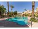 Large community pool with lounge chairs and palm trees on a sunny day at 5335 E Shea Blvd # 1087, Scottsdale, AZ 85254