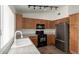 Bright kitchen features wooden cabinets, black appliances, and recessed track lighting at 5401 W Jessica Ln, Laveen, AZ 85339