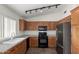 The kitchen includes wooden cabinets, a black appliance package and speckled stone countertops at 5401 W Jessica Ln, Laveen, AZ 85339