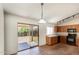 The kitchen includes wooden cabinets, black appliance package and sliding glass door to patio at 5401 W Jessica Ln, Laveen, AZ 85339