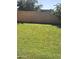 Expansive green lawn surrounded by a block fence and mature trees, offering ample privacy at 5616 W Hidalgo Ave, Laveen, AZ 85339