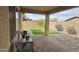 Inviting covered patio with brick pavers, offering serene views of the backyard and privacy wall at 5616 W Hidalgo Ave, Laveen, AZ 85339