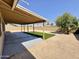 Backyard with covered patio, artificial turf and gravel, with a leafy tree at 6419 W Monte Cristo Ave, Glendale, AZ 85306