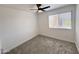 Bright bedroom featuring fresh gray carpet, modern ceiling fan and window at 6419 W Monte Cristo Ave, Glendale, AZ 85306
