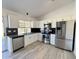 Modern kitchen with stainless steel appliances, white cabinets, and sleek black backsplash at 6419 W Monte Cristo Ave, Glendale, AZ 85306