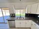 Kitchen area showing stainless steel sink, countertops and cabinets, and sliding glass door to backyard at 6419 W Monte Cristo Ave, Glendale, AZ 85306