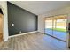 Open living space with modern gray accent wall, hard surface flooring, and a sliding glass door at 6419 W Monte Cristo Ave, Glendale, AZ 85306