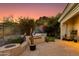 Inviting backyard oasis featuring a built-in grill, fire pit, mature plants, and desert landscape at 6512 N 31St Way, Phoenix, AZ 85016
