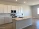 Modern kitchen with white cabinets, stainless steel appliances, a center island, and tile backsplash at 7216 E Blissful Breeze Ln, San Tan Valley, AZ 85143