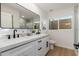 Modern bathroom with dual sinks, white cabinets, black hardware, and tiled shower at 7223 N 14Th St, Phoenix, AZ 85020