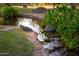 Scenic pond with lush greenery, stone edging, and clear, reflective water for a tranquil outdoor space at 7223 N 14Th St, Phoenix, AZ 85020