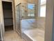 Spa-like bathroom featuring marble-look tile, a glass-enclosed shower, a soaking tub, and a window for natural light at 7259 E Blissful Breeze Ln, San Tan Valley, AZ 85143
