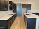 Well-designed kitchen with dark cabinets, stainless steel appliances, a central island, and a stylish tile backsplash at 7259 E Blissful Breeze Ln, San Tan Valley, AZ 85143