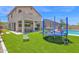 Backyard with artificial grass, trampoline, outdoor seating, and view of house elevation and pool at 7260 E Tasman St, Mesa, AZ 85207