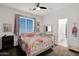 Bright bedroom with colorful bedding, ceiling fan, and access to the bathroom at 7260 E Tasman St, Mesa, AZ 85207