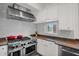Bright kitchen features a stainless steel range, granite countertops, subway tile backsplash, and white cabinets at 7260 E Tasman St, Mesa, AZ 85207
