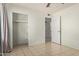 Bedroom boasts tile floors, closet with shelves, and neutral paint scheme at 8339 W Devonshire Ave, Phoenix, AZ 85037