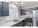 A modern kitchen featuring stainless appliances, gray cabinets, and white backsplash at 8339 W Devonshire Ave, Phoenix, AZ 85037