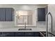 Bright kitchen showcasing stainless sink, gray cabinets, and modern backsplash at 8339 W Devonshire Ave, Phoenix, AZ 85037