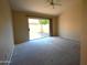 Cozy bedroom with neutral carpet, ceiling fan, and sliding glass door to the backyard at 9285 E Sutton Dr, Scottsdale, AZ 85260