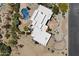 Overhead shot of sprawling desert estate with white roof, a private pool, lush landscaping, and a circular driveway at 9349 E Calle De Valle Dr, Scottsdale, AZ 85255