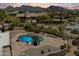 An aerial view showcases the backyard, pool, desert landscaping, and mountain views of this stunning desert home at 9349 E Calle De Valle Dr, Scottsdale, AZ 85255