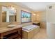 This sunny bathroom features a soaking tub, dual sinks, and a large picture window for scenic views at 9349 E Calle De Valle Dr, Scottsdale, AZ 85255