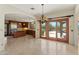 Open dining room showcasing an elegant chandelier, access to outdoor patio, and view into the gourmet kitchen at 9349 E Calle De Valle Dr, Scottsdale, AZ 85255