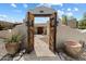 Inviting entrance featuring a rustic wooden gate, landscaped pathway and charming views of the home's facade at 9349 E Calle De Valle Dr, Scottsdale, AZ 85255